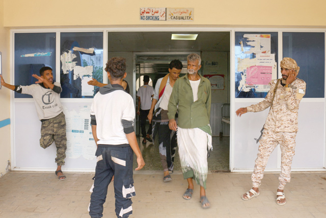 Relatives wait for news on casualties of strikes on Al Anad air base at Ibn Khaldun Hospital in Yemen's government-held southern province of Lahij on Sunday (AFP photo)