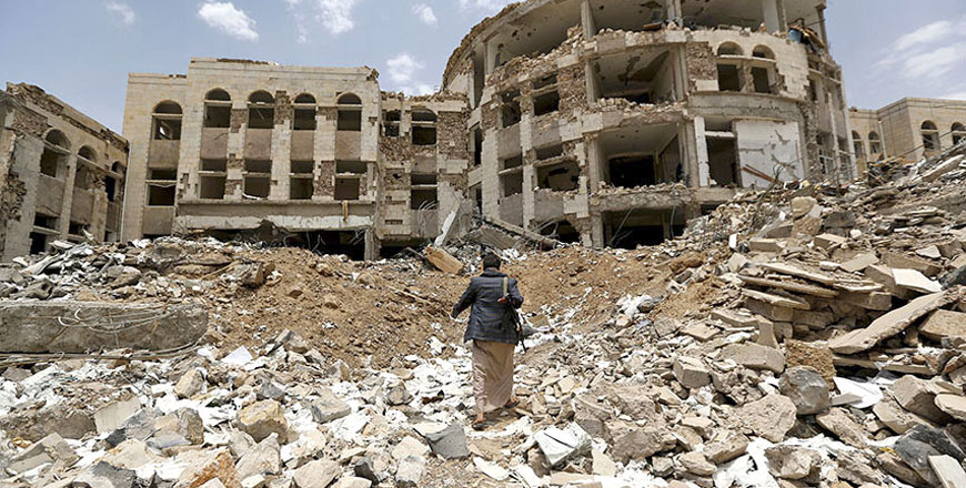 A militant walks through a government compound following Saudi–led strikes in northwestern city of Amran in July 2015 (Reuters photo)