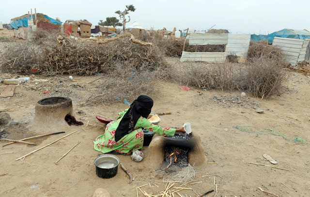 A woman prepares food near a hut in an improvised camp for internally displaced people near Abs of the northwestern province of Hajja, Yemen, on February 18 (Reuters photo)