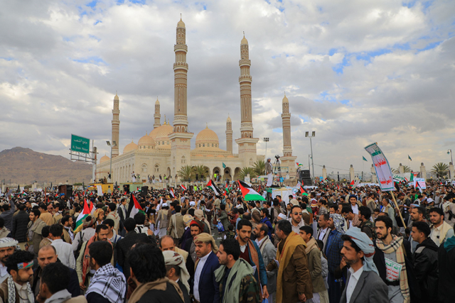 Demonstrators lift placards and Palestinian flags as they rally in the Houthi-run capital Sanaa on Friday (AFP photo)