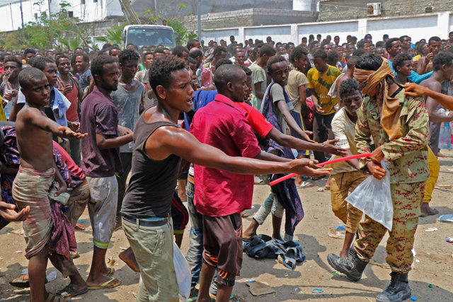 African migrants receive food and water inside a football stadium in the Red Sea port city of Aden, Yemen, on Tuesday (AFP photo)
