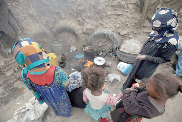 Women cook a meal after they received food aid from the local charity, Mona Relief, ahead of the holy month of Ramadan in a slum on the outskirts of Sanaa, Yemen, on Sunday (Reuters photo)