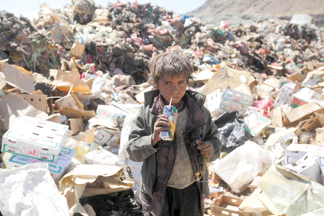 A boy drinks expired juice on a pile of rubbish at landfill site on the outskirts of Sanaa, Yemen, on  November 16, 2016 (Reuters photo)