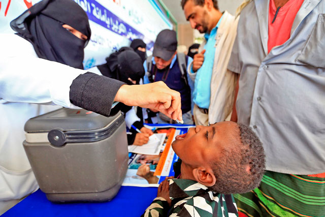 A Yemeni child receives an oral cholera vaccine from a Houthi rebel-run health authorities volunteer during a vaccination campaign in the capital Sanaa on Saturday (AFP photo)