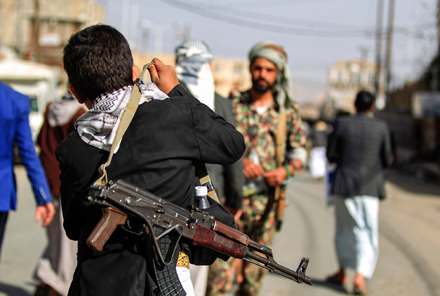 A Yemeni boy adjust on his shoulder the strap of a Kalashnikov assault rifle in the Houthi rebel-held capital Sanaa, on Friday (AFP photo)