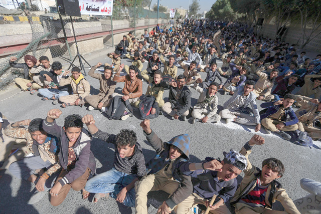 Young supporters of Yemen's Houthi movement raise their fists up as they chant slogans during a demonstration in front of the closed US embassy in the capital Sanaa on Monday (AFP photo)