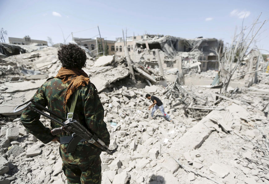 A soldier looks at houses destroyed by a Saudi-led air strike that targeted a nearby office of Ahmed Ali Abdullah Saleh, the eldest son of Yemen's former president Ali Abdullah Saleh in Sanaa, Yemen, on Monday (Reuters photo)