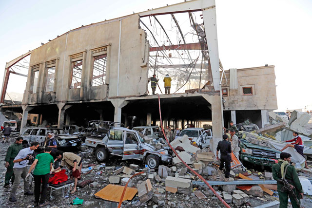 People inspect the aftermath of an air strike in Sanaa, Yemen, on Saturday (AP photo)