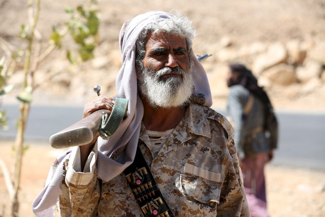 A tribal militant loyal to Yemen’s government holds his weapon as he secures a road taken over by the  pro-government army and tribal fighters from Houthi militants in Furdhat Nihem area near the capital Sanaa, on Wednesday (Reuters photo)