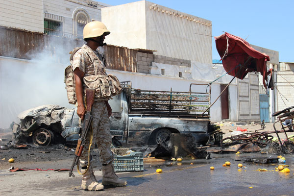 A soldier stands at the site of a car bomb attack in a central square in the port city of Aden, Yemen, on Sunday, that targeted the city’s security chief for the second time in a week (Reuters photo)