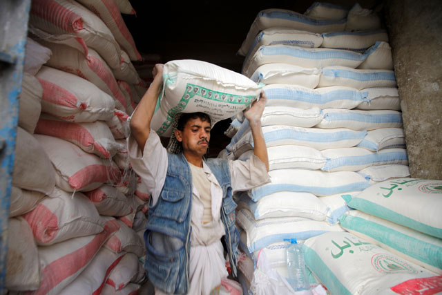 A worker carries a sack of wheat flour at a store in Sanaa, Yemen, on Wednesday (Reuters photo)