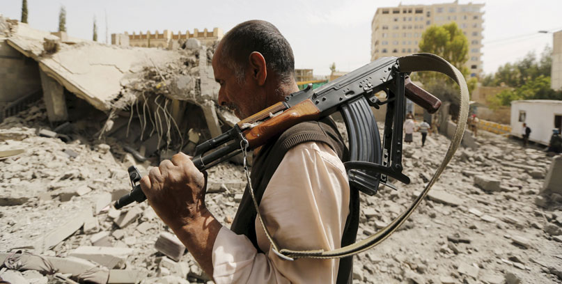 A guard walks past the house of Brigadier Fouad Al Emad, an army commander loyal to the Houthis, after Saudi-led air strikes destroyed it in Sanaa on Monday (Reuters photo)