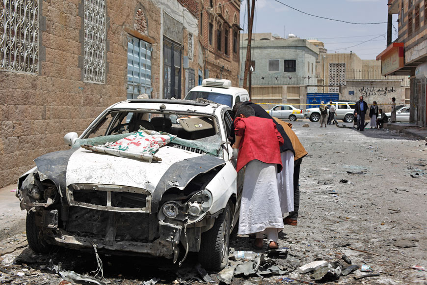 People look at the site of a car bomb attack in Sanaa on Tuesday. The explosion occurred near a military hospital in the Yemeni capital on Monday, causing dozens of casualties including civilians, security officials said (AP photo)