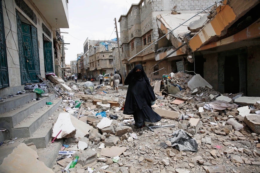 A woman walks amid the rubble of houses destroyed by a Saudi-led air strikes in Sanaa on Monday (AP photo)