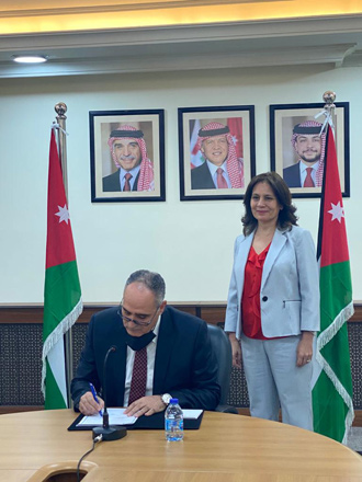 Director General of the National Electric Power Company (NEPCO) Amjad Rawashdeh signs a contract to connect the electric power grids of Jordan and Iraq in the presence of Energy Minister Hala Zawati on Sunday (Photo courtesy of the Energy Ministry)