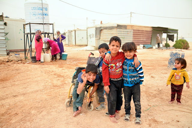 Young Syrian refugees pose for a photo at the Zaatari Refugee Camp in Mafraq Governorate (Photo by Amjad Ghsoun)