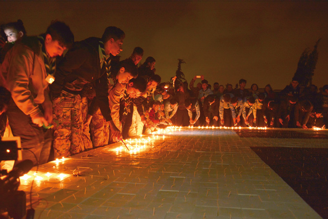 Volunteers help build a record-breaking candle mosaic logo of Earth Hour in Amman on Saturday (Photo by Amjad Ghsoun)