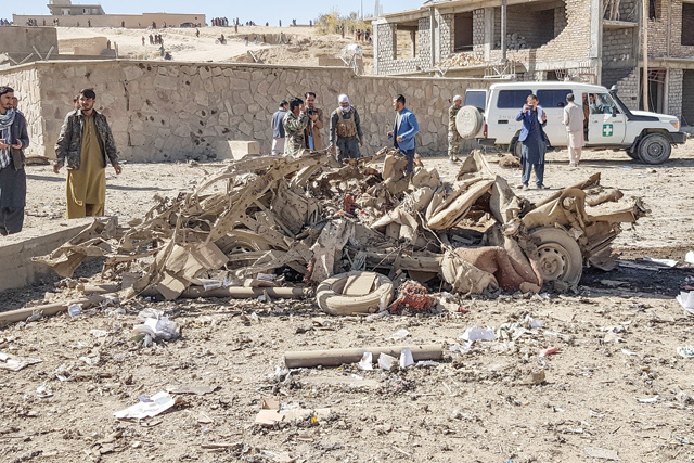 In this file photo taken on October 18, 2020, security personnel and residents gather around the site of a car bomb attack that targeted an Afghan police headquarters in Feroz Koh, the capital of Ghor Province (AFP photo)