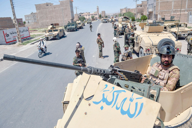 An Afghan National Army commando stands guard on top of a vehicle along the road in Enjil district of Herat province on Sunday, as skirmishes between Afghan National Army and Taliban continue (AFP photo)