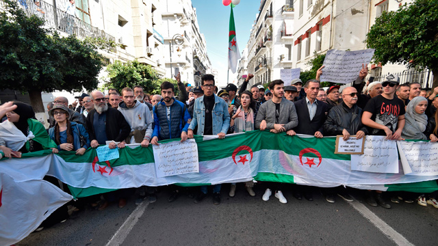 Protesters chant slogans as they march with signs and Algerian national flags during an anti-government demonstration in the capital Algiers on Tuesday (AFP photo)
