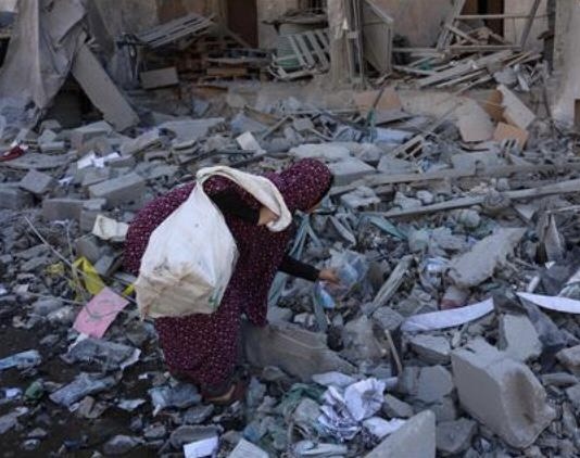 A Palestinian woman inspects the rubble of the Elias Tarazi family house, after it was destroyed in an Israeli strike in Al Sabra neighbourhood in Gaza City on March 19, 2025 (AFP photo)
