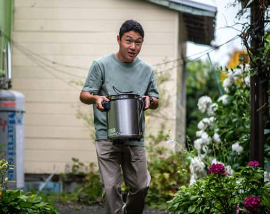 Koichi Miyatsu carries a pot from his home to a monthly charity event for underprivileged children in Kumamoto on March 11  (AFP photo by Philip Fong)