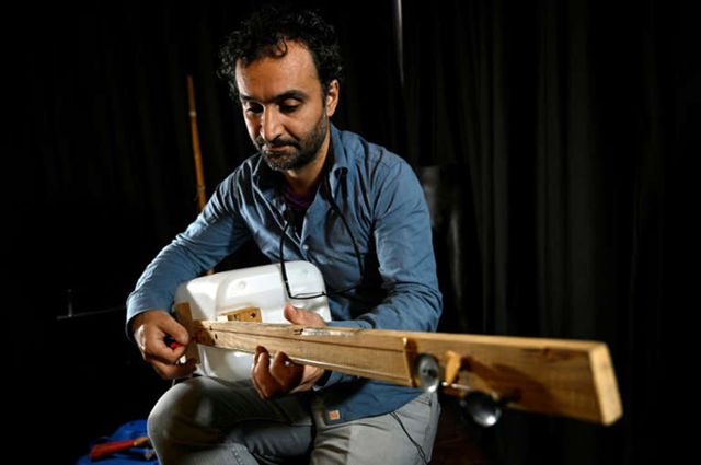 Band member from Fungistanbul, a trio of musicians who turn rubbish into instruments to promote recycling and a cleaner environment, plays his instrument  (AFP photo by Ozan Kose)