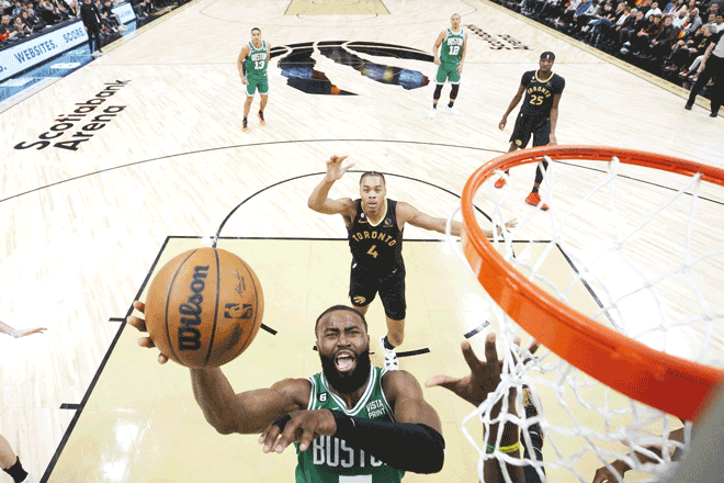 Jaylen Brown of the Boston Celtics goes to the net as Scottie Barnes of the Toronto Raptors trails behind during their NBA game in Toronto, Canada, on Saturday (AFP photo by Cole Burston)