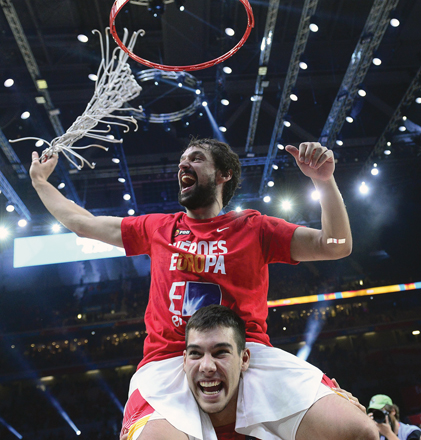 Spain’s point guard Sergio Llull (top) and centre Guillermo Hernangomez grab the basketball net as they celebrate beating Lithuania for the EuroBasket 2015 title in Lille, on Sunday (AFP photo by Emmanuel Dunand)