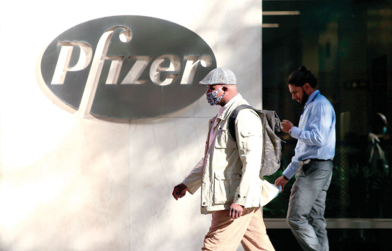 People walk by the Pfizer world headquarters in New York on Monday (AFP photo)