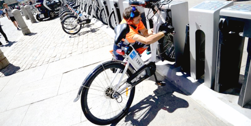 A municipal employee carries out preventative maintenance and repairs on a BiciMad public electric bikes share station in Madrid on August 13, 2015 (AFP photo)