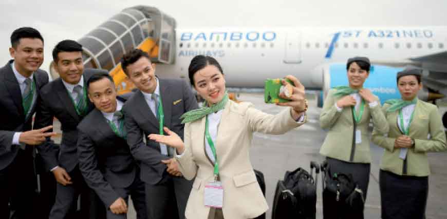 Flight attendants of Vietnam’s newly launched Bamboo Airways are seen in front of their new Airbus A321Neo during a welcoming ceremony on the airline’s first day of operation at the Noi Bai Domestic airport in Hanoi on Wednesday (AFP photo)