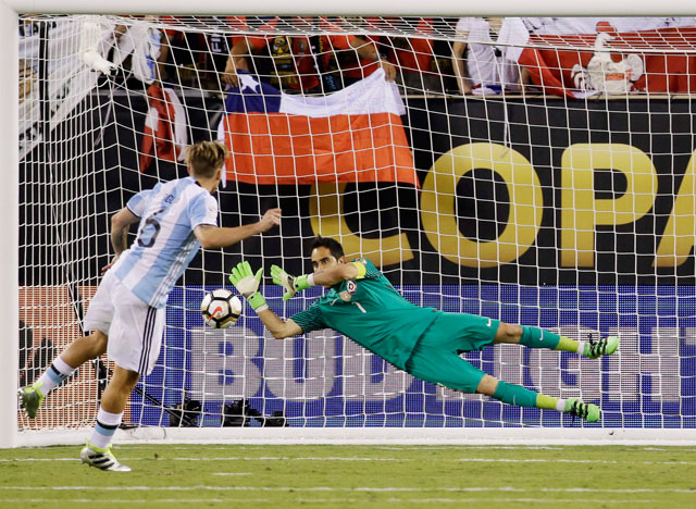  Chile goalkeeper Claudio Bravo blocks a shot by Argentina’s Lucas Biglia during penalty kicks in the Copa America championship football match in East Rutherford, New Jersey, on Sunday (AP photo by Julio Cortez)
