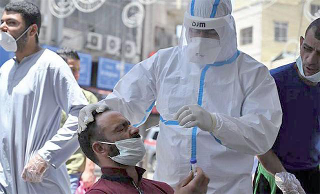 Ahealthcare worker collects a sample from a man during a coronavirus test in Amman in this recent photo (JT file photo)