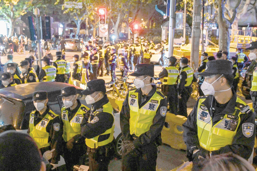 Police officers block Wulumuqi Street, named for Urumqi in Mandarin, in Shanghai on Sunday, in the area where protests against China's zero-COVID policy took place the night before following a deadly fire in Urumqi, the capital of the Xinjiang region (AFP photo)