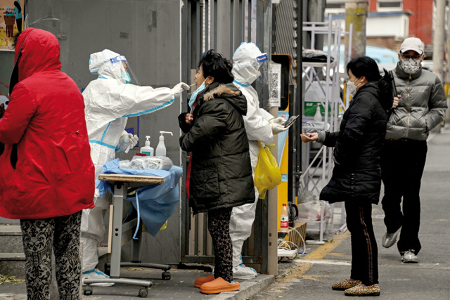 Residents undergo swab testing at a residential area under lockdown due to COVID-19 coronavirus restrictions in Beijing on Tuesday (AFP photo)