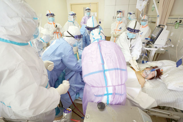 Medical staff treating a critical patient infected by the COVID-19 coronavirus with an Extracorporeal membrane oxygenation at the Red Cross hospital in Wuhan in China's central Hubei province on Sunday (AFP photo)