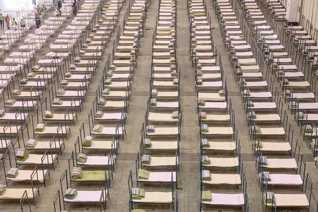 Workers set up beds at an exhibition centre that was converted into a hospital in Wuhan in China's central Hubei province on Tuesday (AFP photo)