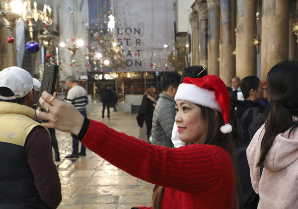 Pilgrim takes a selfie at the Church of the Nativity in the city of Bethlehem in the occupied West Bank on Sunday (AFP photo)