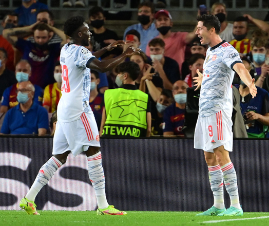 Bayern Munich’s Robert Lewandowski (right) celebrates his goal with Alphonso Davies during their UEFA Champions League first round match against Barcelona in Barcelona on Tuesday  (AFP photo by Lluis Gene)