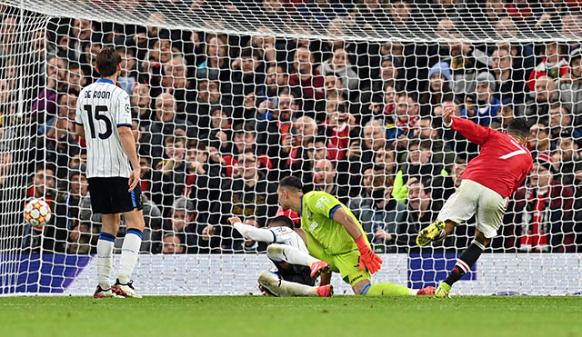 Manchester United's Portuguese striker Cristiano Ronaldo (right) scores his team's third goal against Atalanta during their UEFA Champions League group F match in Manchester, England, on Wednesday (AFP photo by Paul Ellis)