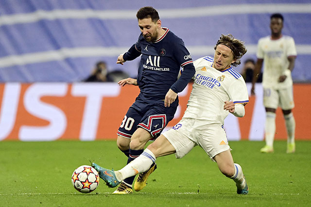 Paris Saint-Germain's Argentinian forward Lionel Messi (left) vies with Real Madrid's Croatian midfielder Luka Modric during their UEFA Champions League round of 16 second league match in Madrid on Wednesday (AFP photo by Javier Soriano)