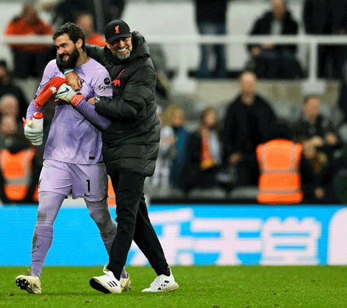 Liverpool’s German manager Jurgen Klopp (right) congratulates Liverpool’s Brazilian goalkeeper Alisson Becker at the end of their English Premier League match against Newcastle United in Newcastle-upon-Tyne on Saturday (AFP photo by Oli Scarff)