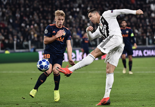 Juventus’ Portuguese forward Cristiano Ronaldo shoots on goal past Valencia’s Danish midfielder Daniel Wass during their UEFA Champions League group H football match in Turin on Tuesday  (AFP photo by Marco Bertorello)