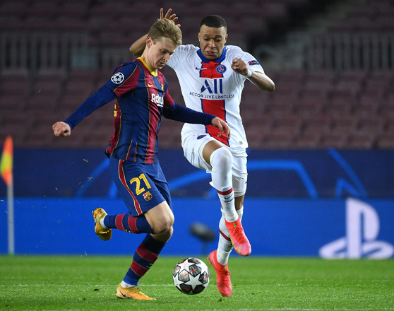 Paris Saint-Germain’s French forward Kylian Mbappe (right) challenges Barcelona’s Dutch midfielder Frenkie De Jong during their UEFA Champions League round of 16 first leg match in Barcelona on Tuesday (AFP photo by Lluis Gene)