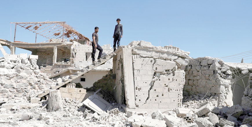 Men inspect a damaged house in Busra Al Harir town, near Deraa, Syria, on March 13 (Reuters file photo)