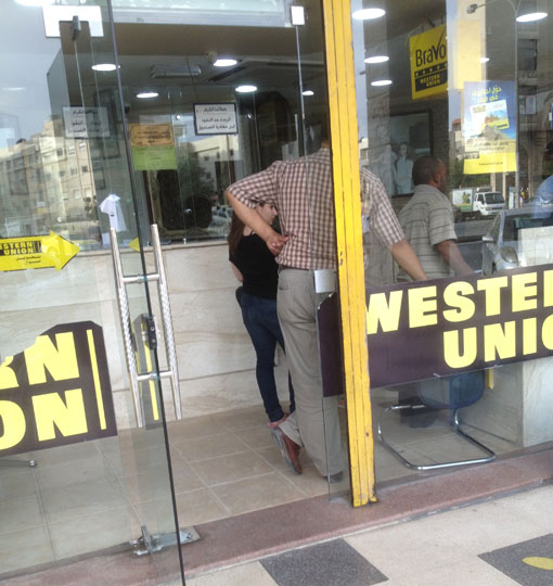 People wait to change money at a currency exchange shop in Amman on Saturday (Photo by Omar Obeidat)