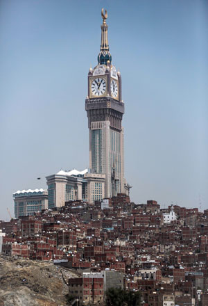 In this September 17 file photo, the tallest clock tower in the world with the world's largest clock face, atop the Abraj Al Bait Towers, overshadows mountain slums in the holy city of Mecca (AP photo)