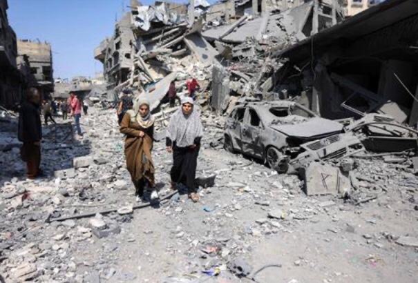 People walk amid the rubble of a building destroyed in an overnight Israeli strike in Jabalia, in the northern Gaza Strip on March 18, 2025 (AFP photo)