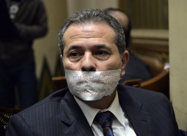 Tawfiq Okasha, a pro-government TV anchorman who was elected to parliament, sits in an anteroom after he taped his mouth shut in protest at not being given the floor during a parliamentary session, in Cairo, Egypt, on Tuesday (AP photo)